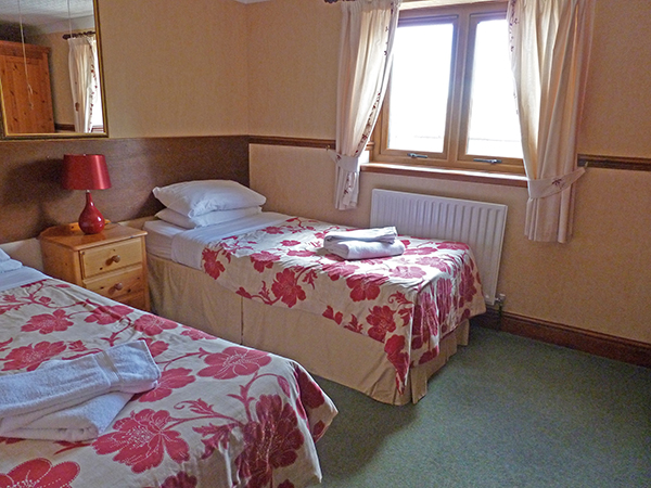 Ashwood Lodge's Bedroom 4 is a bright twin room equipped with a dressing table.