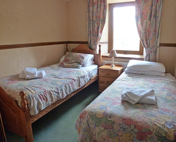 Bedroom 5 in Ashwood Lodge is a twin room. When it was a farm building, it was the grain attic, feeding the mill on the ground floor to mill animal feed for the farm.