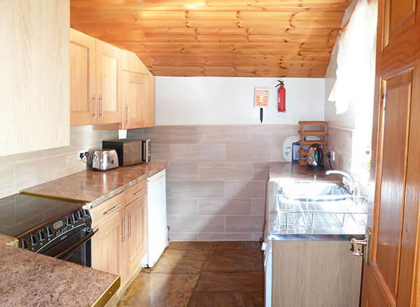 The kitchen in Bide-A-Wee cottage is equipped with cooker, fridge & ice-box, dishwasher and washing machine
